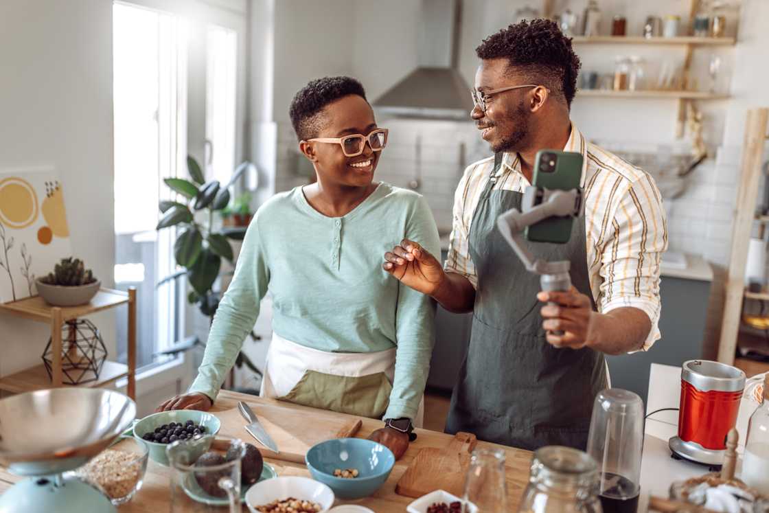 A young couple filming a kitchen challenge.