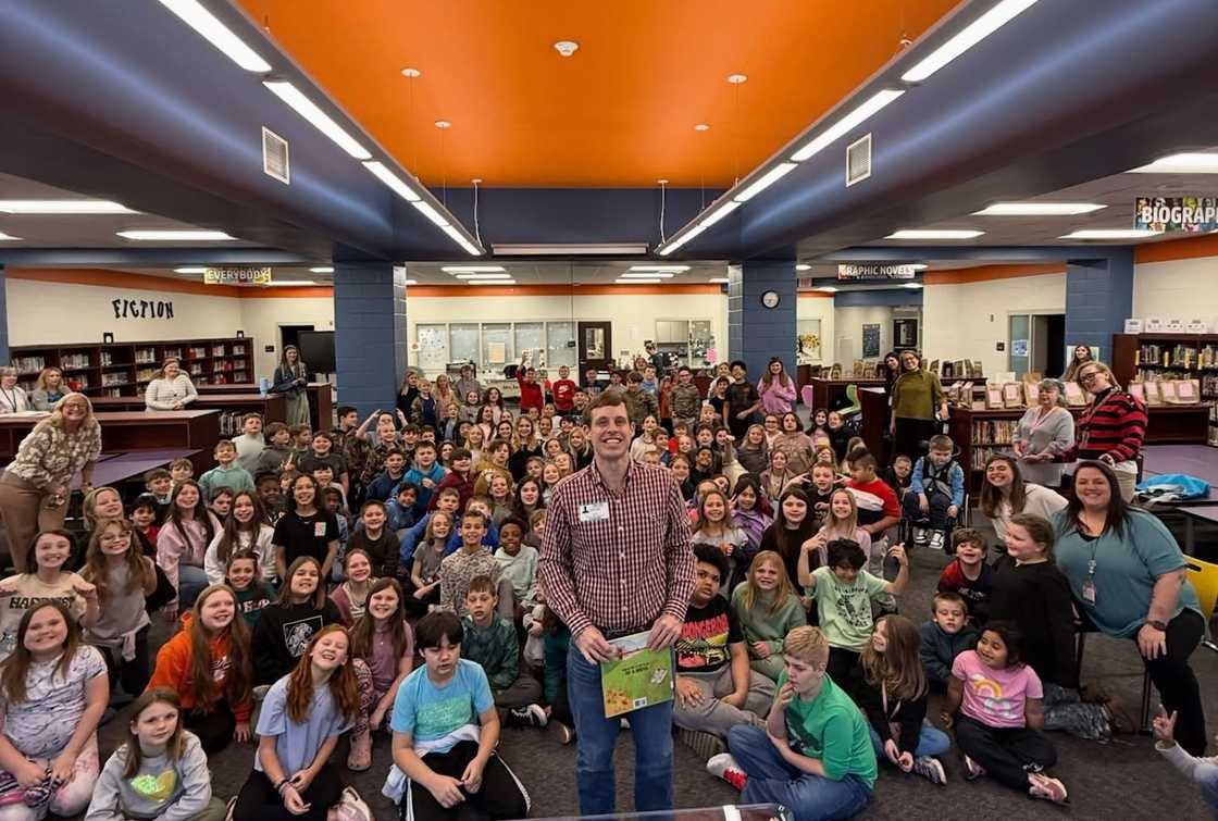 Tanner Smith poses infront of children in a library Tanner Smith poses infront of children in a library