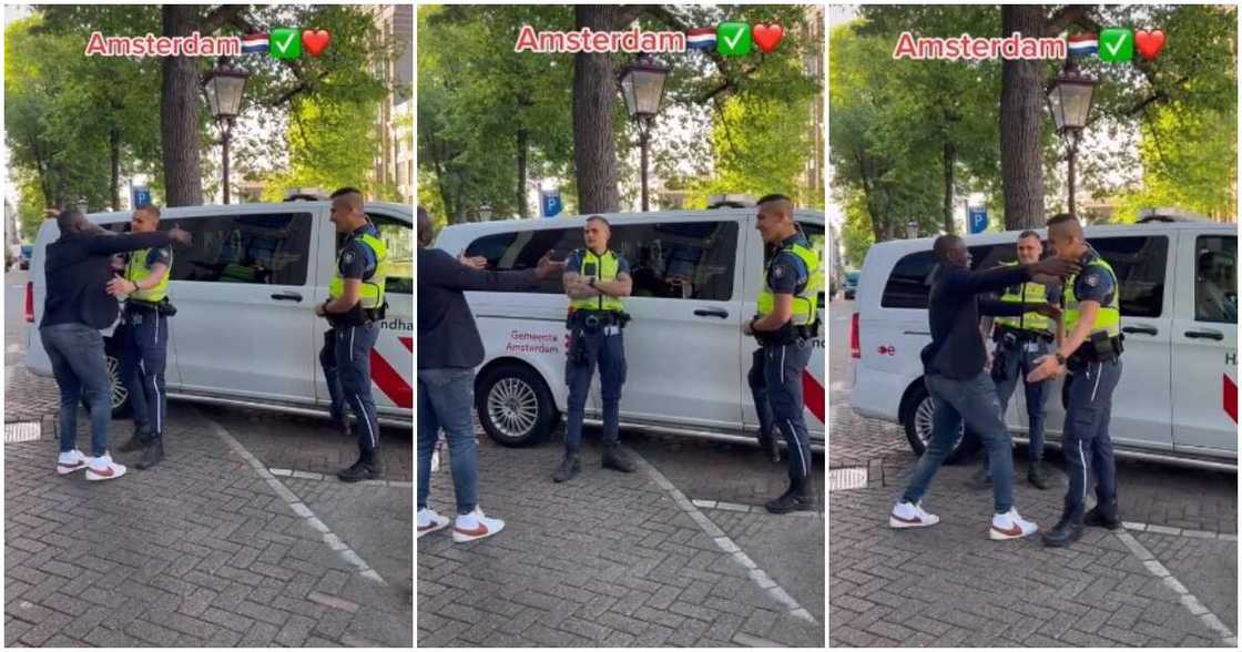 Amsterdam, Netherlands, black man, white policemen, hugs them, walks away Amsterdam, Netherlands, black man, white policemen, hugs them, walks away