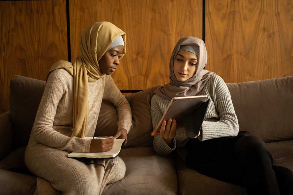 Two female student checking a tablet