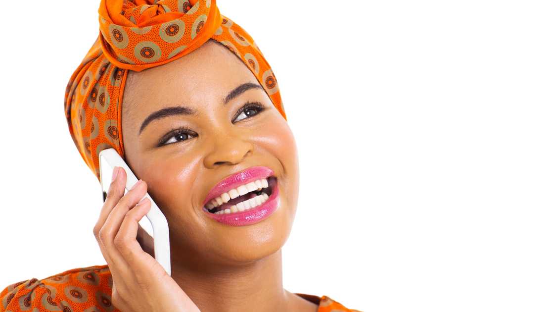 A woman talks on her cell phone against a white background. A woman talks on her cell phone against a white background.