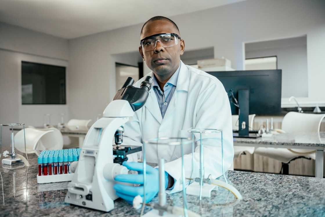 Man doing analysis in the laboratory looking at the microscope. Man doing analysis in the laboratory looking at the microscope.