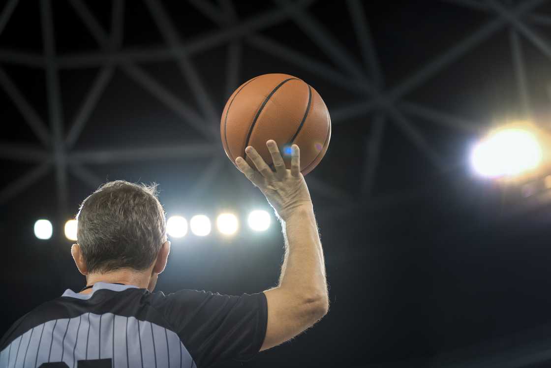 A basketball referee holding a ball