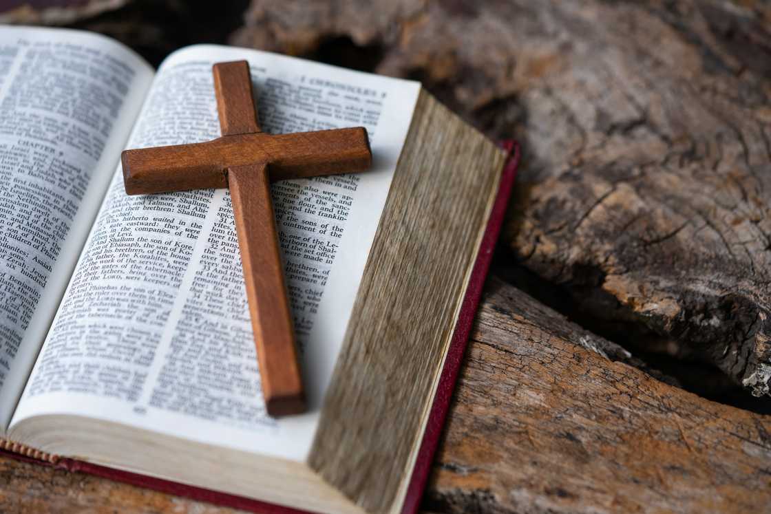 A wooden cross and Holy Bible on a table