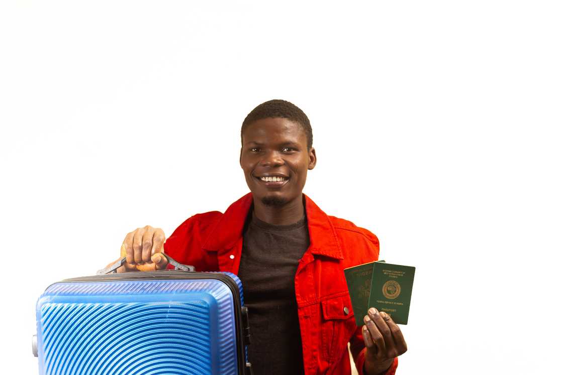 A young man wearing holding a passport. A young man wearing holding a passport.