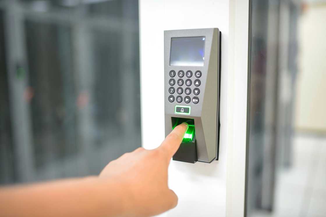 A hand is pictured using a biometric fingerprint machine