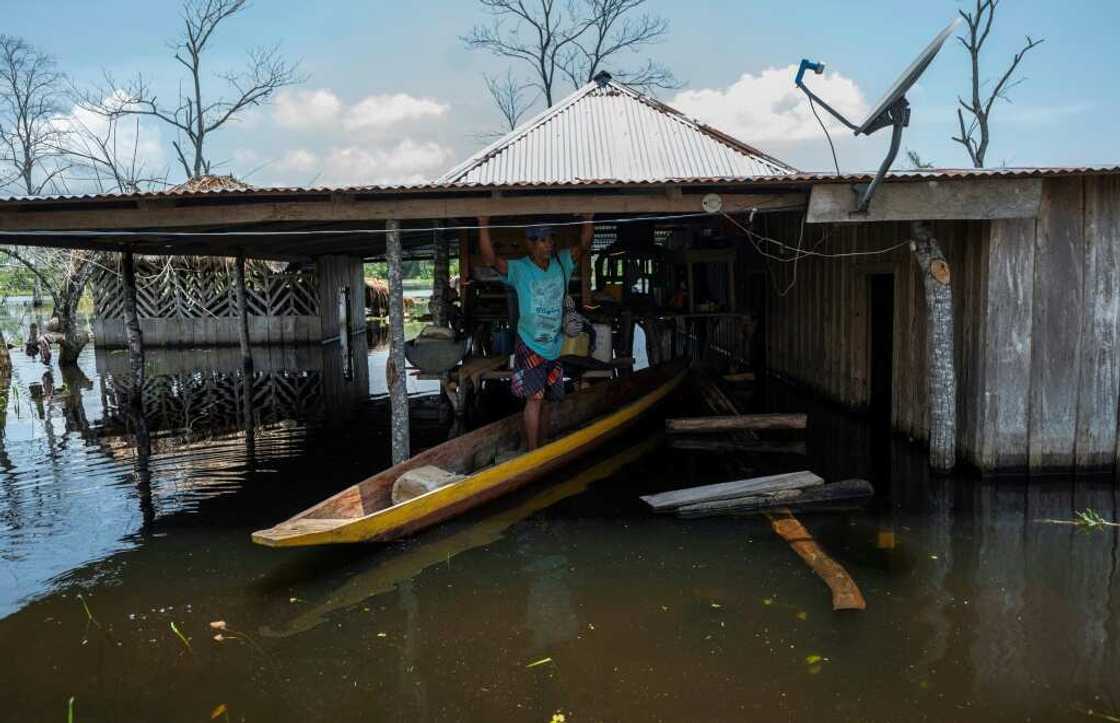 Residents travel by canoe from one house to the other. Luckier households, where the water has receded, have to contend with the mud Residents travel by canoe from one house to the other. Luckier households, where the water has receded, have to contend with the mud