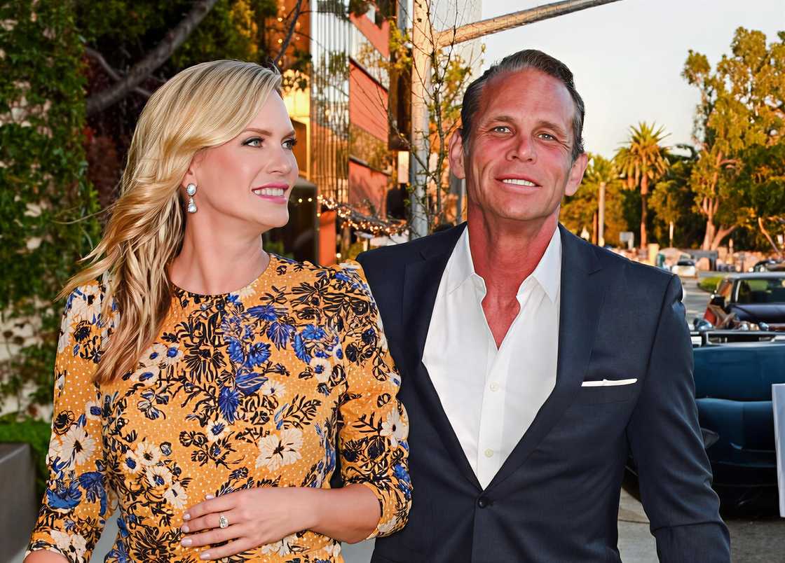 Chris Browning and Natasha Henstridge walk on a sidewalk.