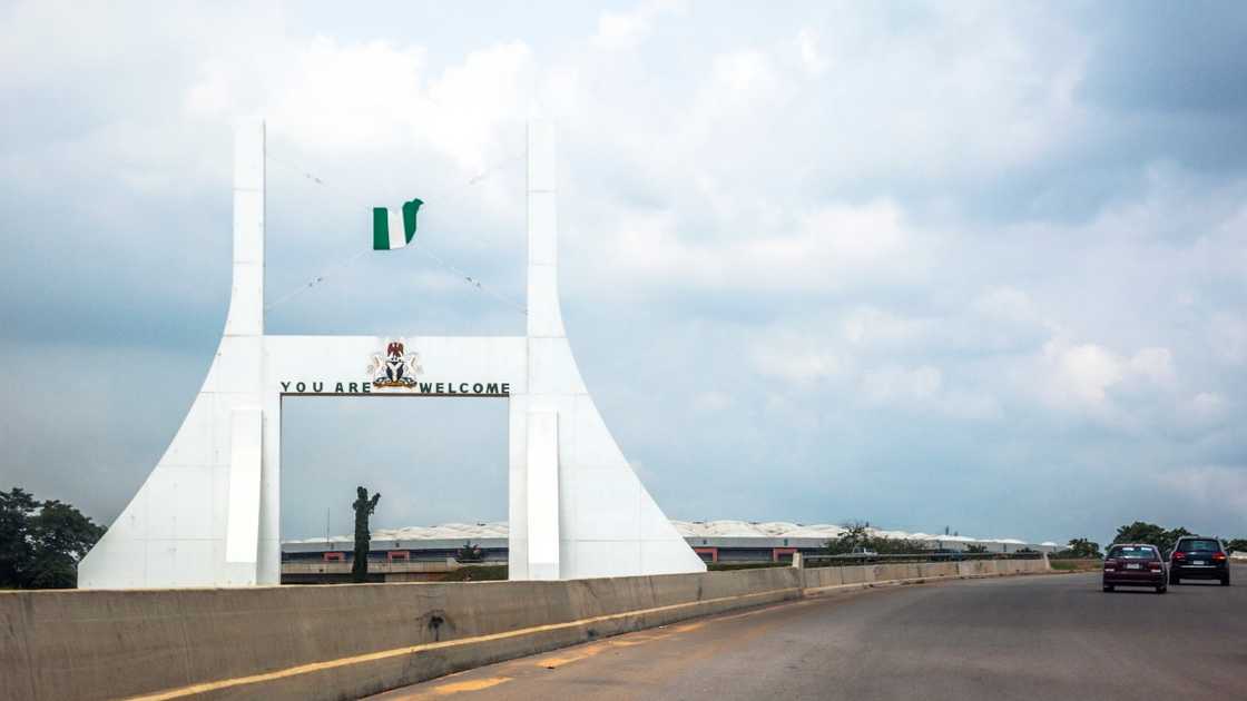 Abuja's City Gate with the Nigerian national flag flying above it.