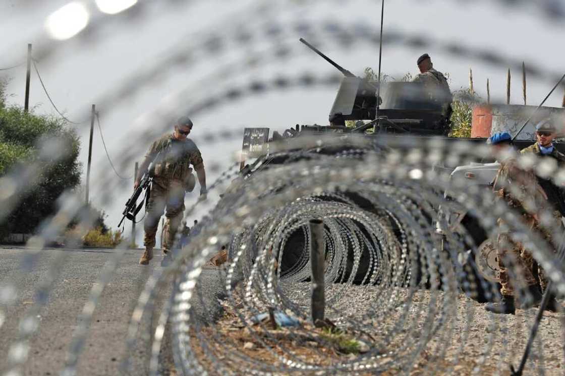 Lebanese army soldiers (L) stand by an infantry-fighting vehicle (IFV) near peacekeepers (R) of the United Nations Interim Force In Lebanon (UNIFIL) in Naqura along the border with northern Israel on Thursday Lebanese army soldiers (L) stand by an infantry-fighting vehicle (IFV) near peacekeepers (R) of the United Nations Interim Force In Lebanon (UNIFIL) in Naqura along the border with northern Israel on Thursday