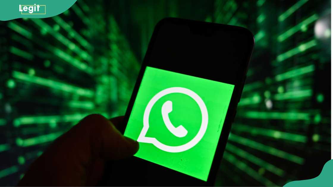 A WhatsApp logo displayed on a smartphone with cyber security symbol on the background.