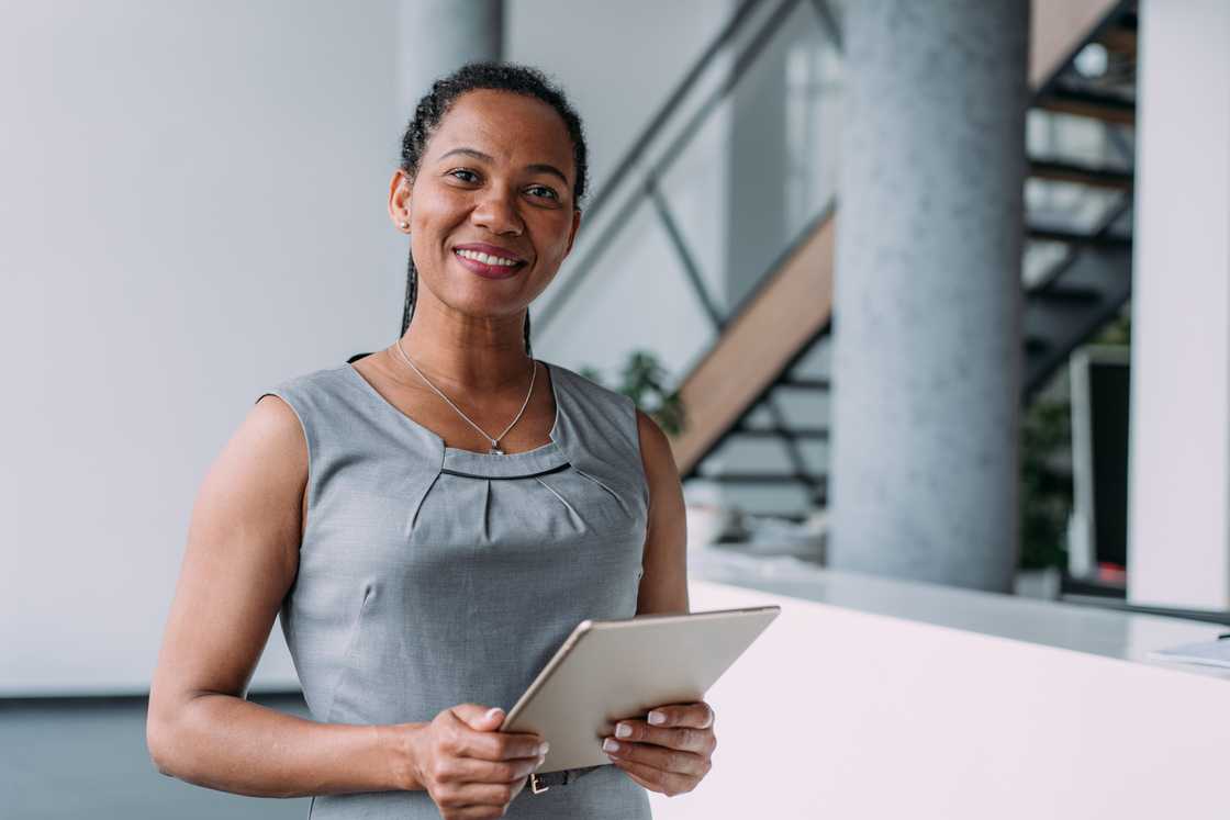 A woman holding digital tablet in the office. A woman holding digital tablet in the office.