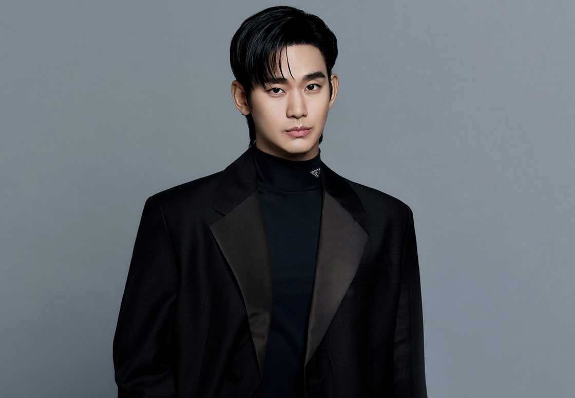 Kim Soo-hyun poses in a black outfit against a grey background.