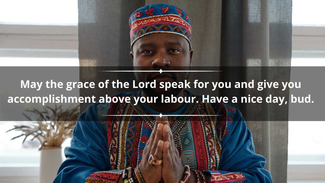 A man in a colourful African outfit is holding his hands in prayer