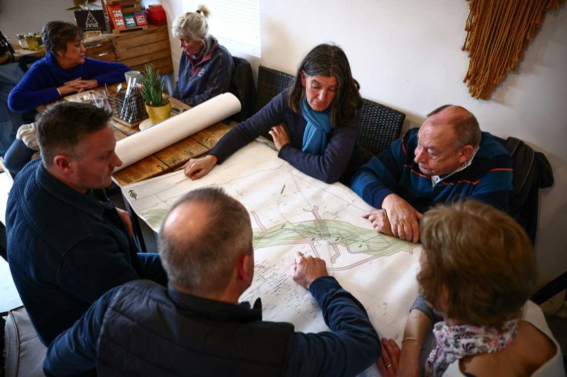 Rosie Pearson speaks with other local residents as they look at a National Grid statutory consultation map outlining proposed plans for a new electricity pylon route in Ardleigh, eastern England Rosie Pearson speaks with other local residents as they look at a National Grid statutory consultation map outlining proposed plans for a new electricity pylon route in Ardleigh, eastern England