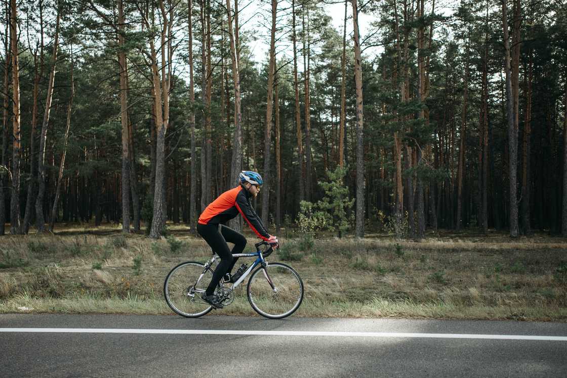 A man riding a bicycle on the roadside. A man riding a bicycle on the roadside.
