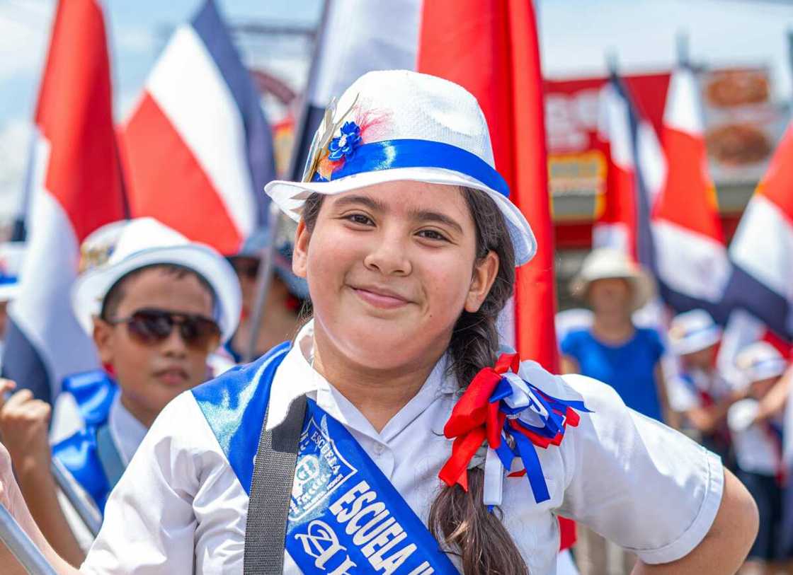 A smiling young girl in uniform at a parade in Costa Rica