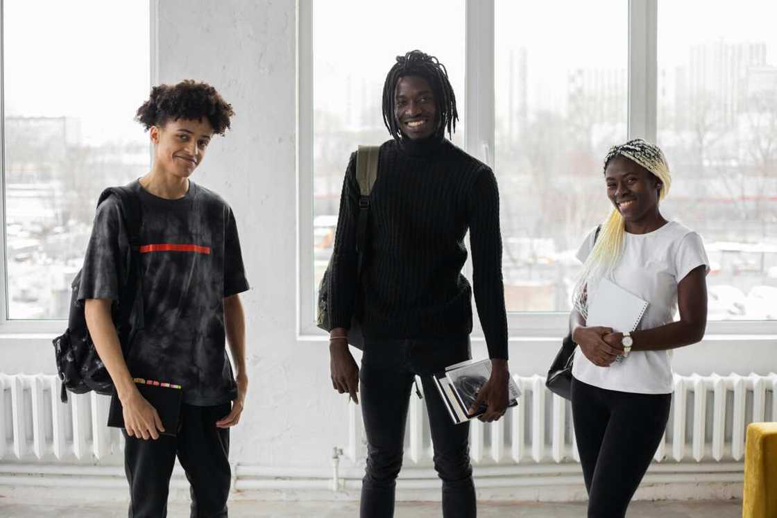 Three students posing for a photo in a classroom