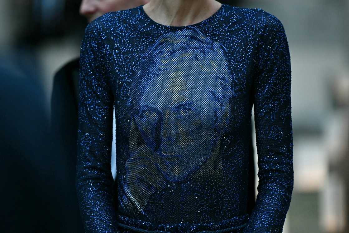 The final dress in the show, a sweeping blue glittering gown, featured the Armani's face, drawing applause The final dress in the show, a sweeping blue glittering gown, featured the Armani's face, drawing applause