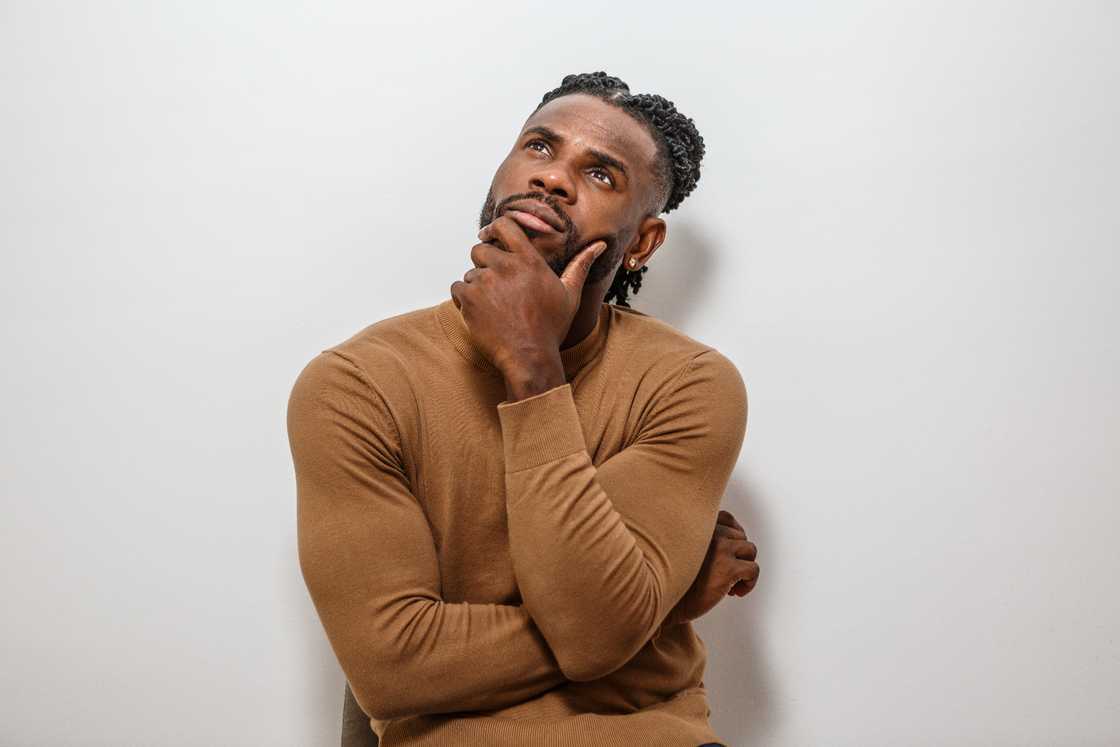 A man sits pensively, deep in thought A man sits pensively, deep in thought