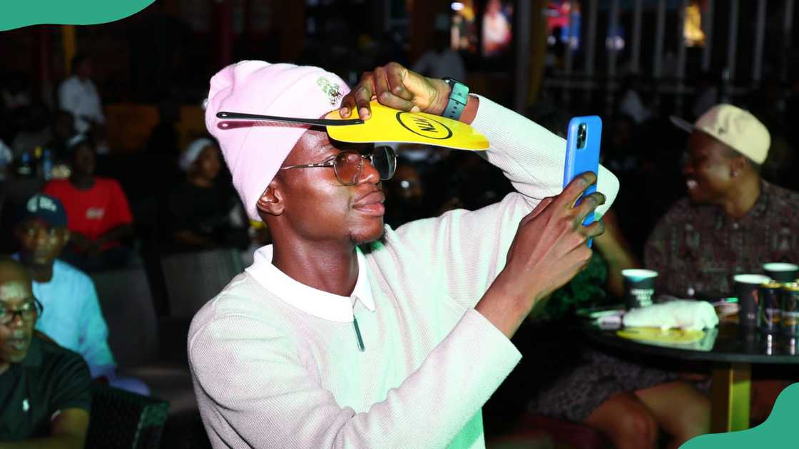A young man uses his phone at an entertainment joint