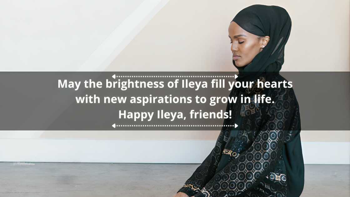 A Muslim woman in black seated on the floor in prayer A Muslim woman in black seated on the floor in prayer