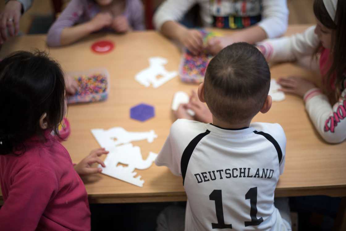 Children sit at a table, playing