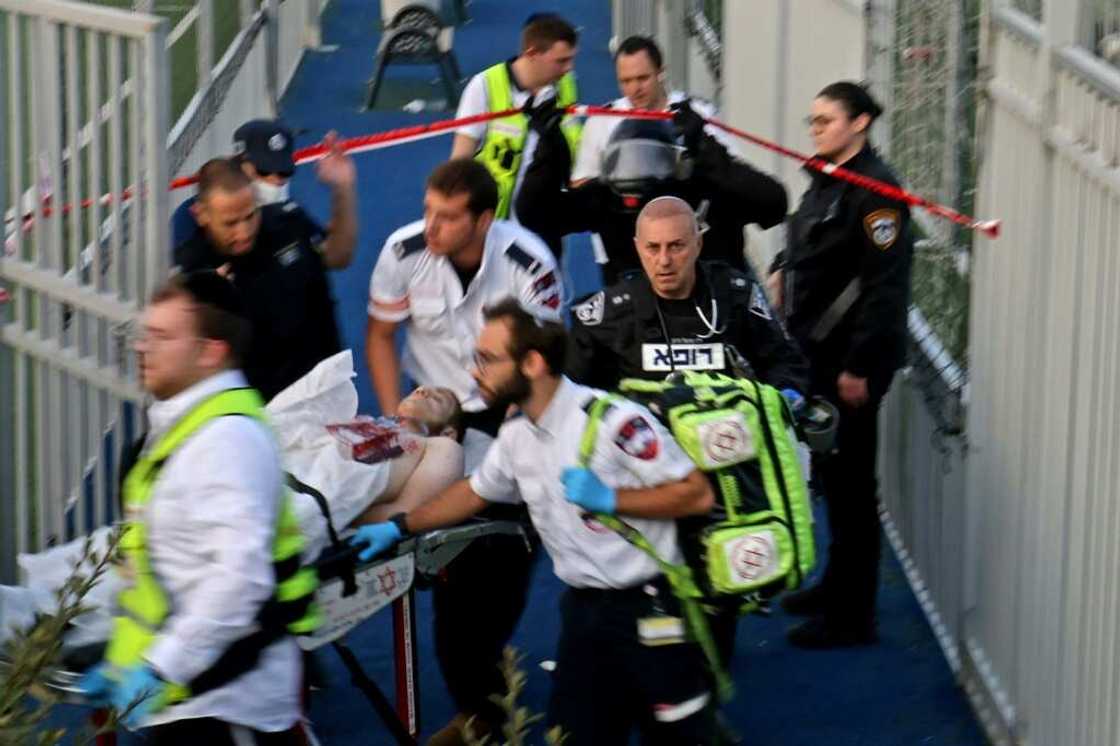 Israeli security forces and emergency personnel carry away a Palestinian man, shot after a stabbing attack in east Jerusalem