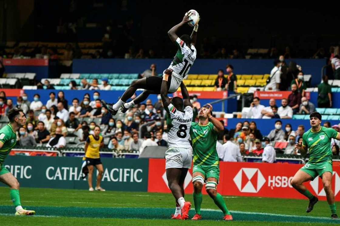 Kenya's Johnstone Olindi (top) is lifted by teammate Herman Humwa (C) against Ireland in the Hong Kong Sevens rugby tournament on November 4, 2022.