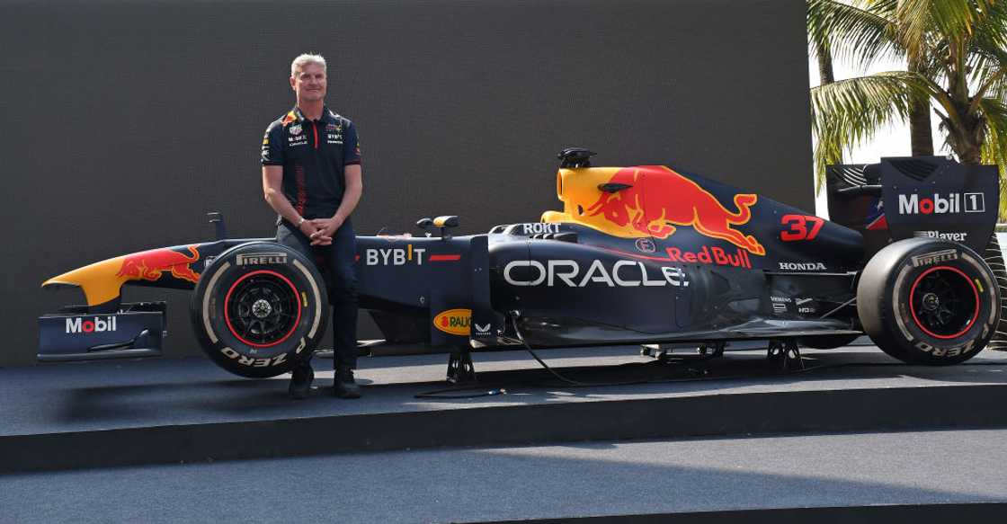 Former Formula One car driver David Coulthard stands next to the Red Bull RB7