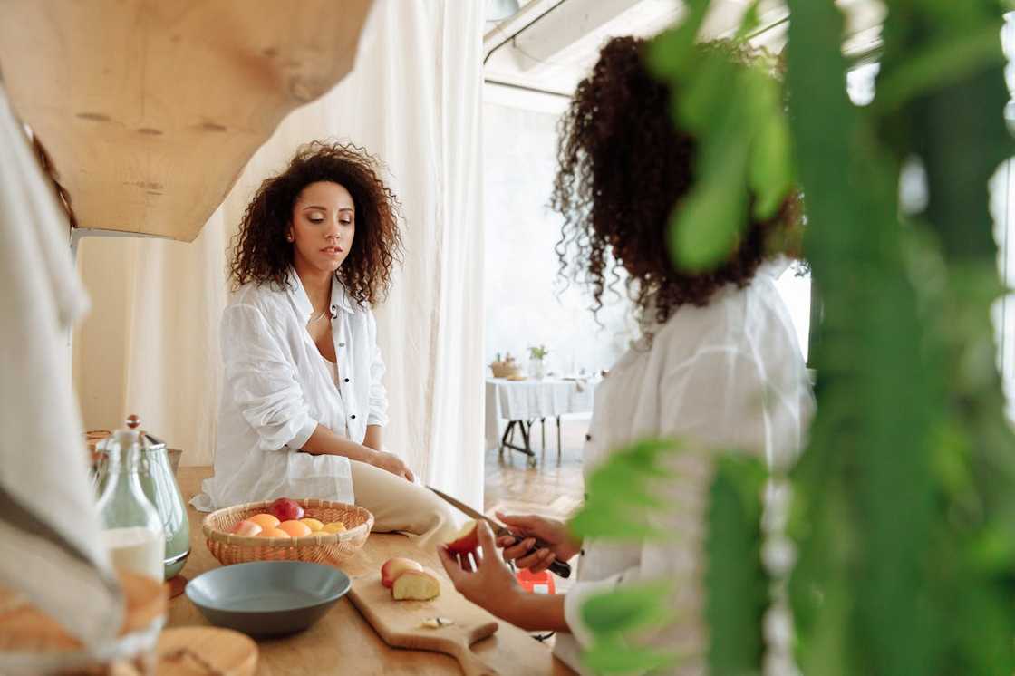 Two women prepare food in the kitchen. Two women prepare food in the kitchen.