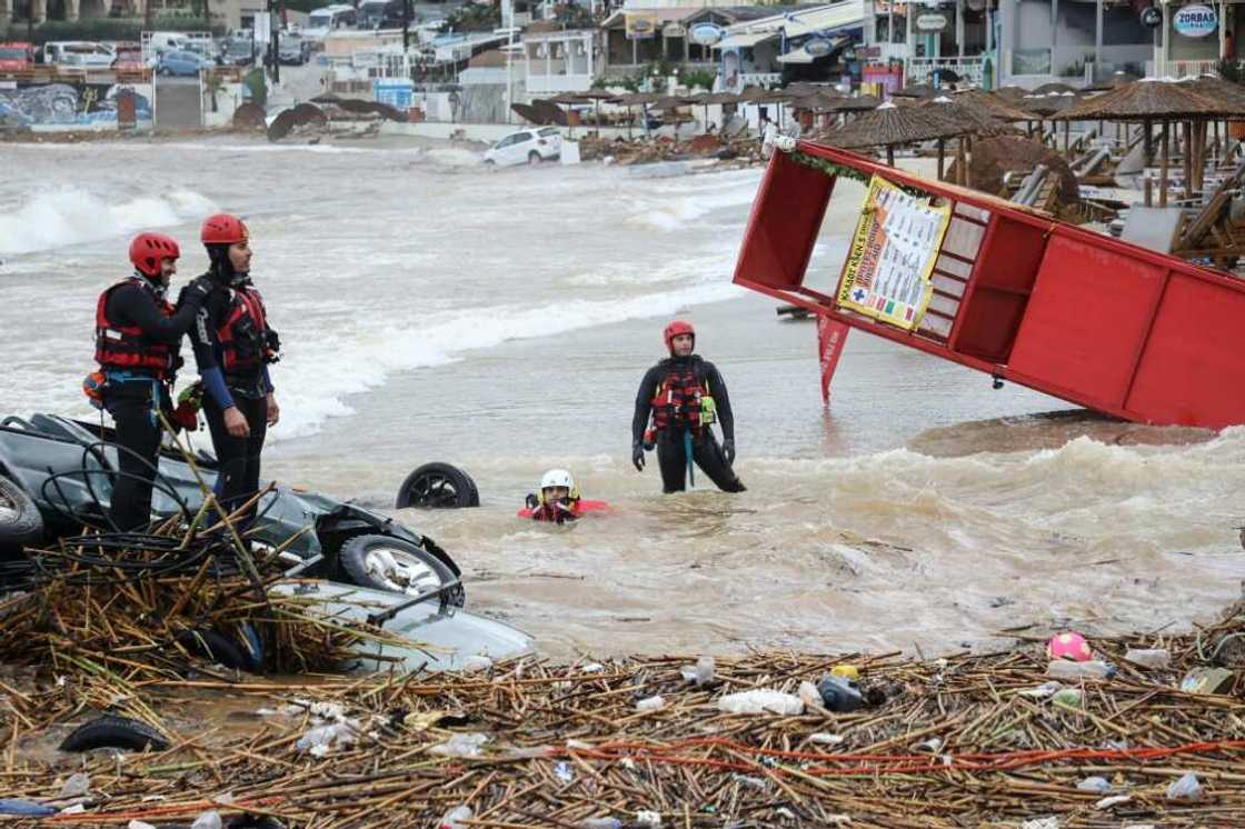 Rescue workers perform a search along the beach of the popular resort of Agia Pelagia, on the southern Greek island of Crete, following flash floods cause by torrential rain, on October 15, 2022