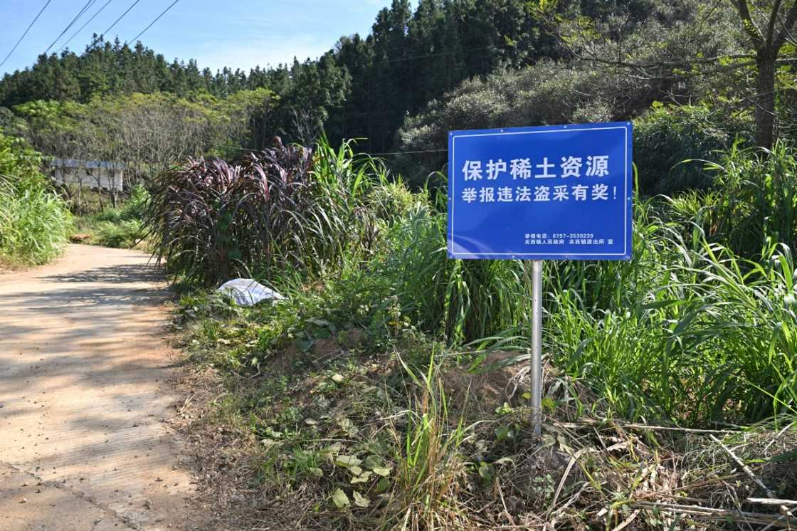 Signage announcing a reward for those who report illegal rare earth mining activities, in Dingnan County in eastern China
