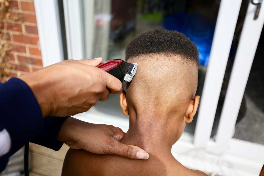 A young boy getting his hair trimmed. A young boy getting his hair trimmed.