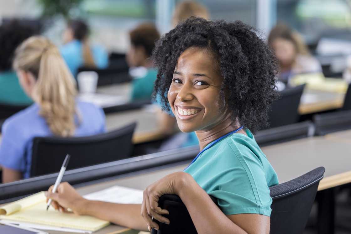 A student in a classroom smiles