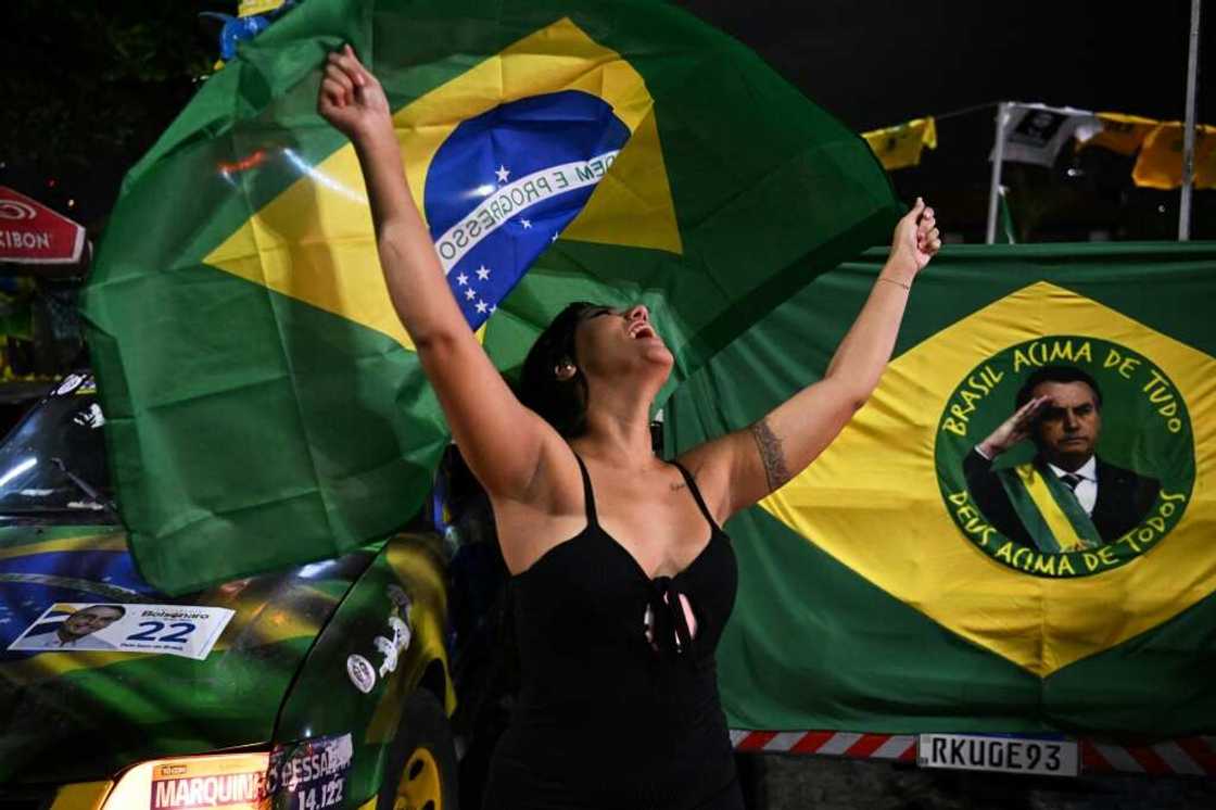 A supporter of far-right President Jair Bolsonaro waving the flag on election day A supporter of far-right President Jair Bolsonaro waving the flag on election day