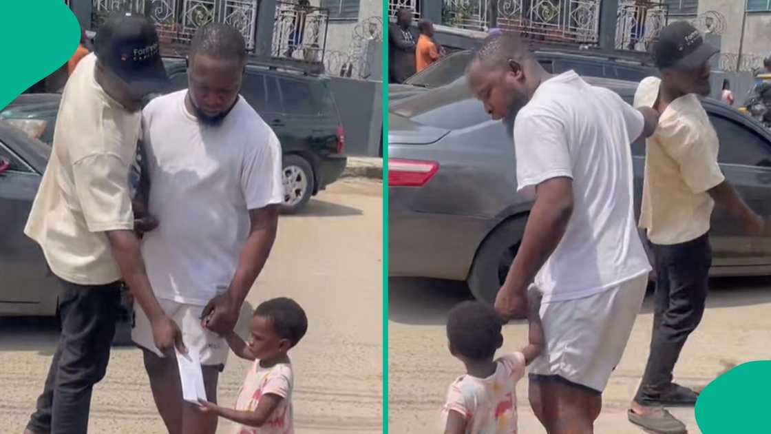 A Nigerian father holding his kid'd hand react after stranger came