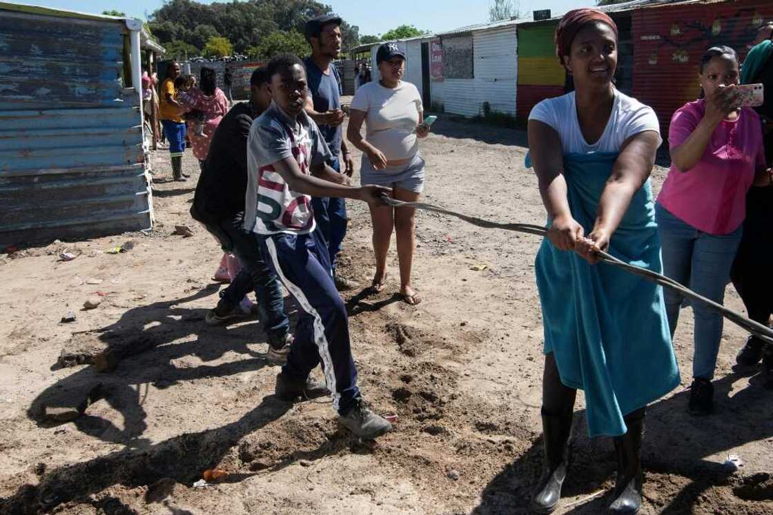 Tug-of-war: residents try to hang on to illegal electricity lines at Oasis Farm near Cape Town Tug-of-war: residents try to hang on to illegal electricity lines at Oasis Farm near Cape Town