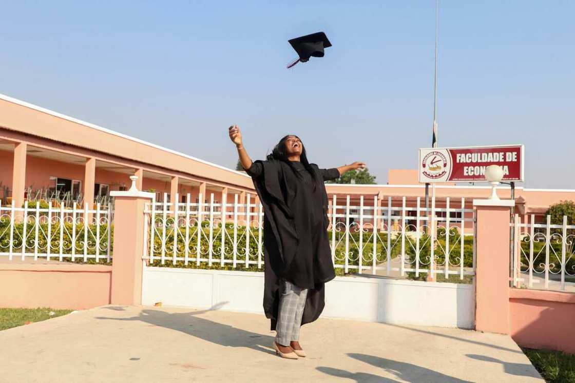 A woman tossing her graduation hat