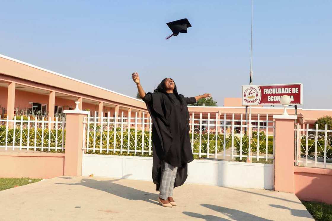 A woman tossing her graduation hat A woman tossing her graduation hat
