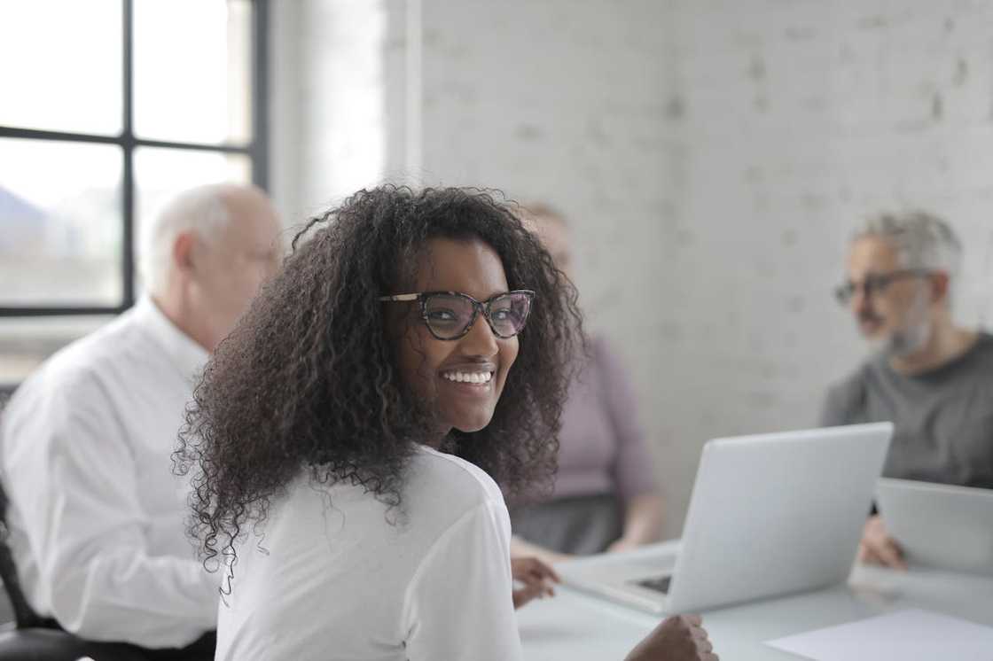 A woman smiles while in a conference meeting.