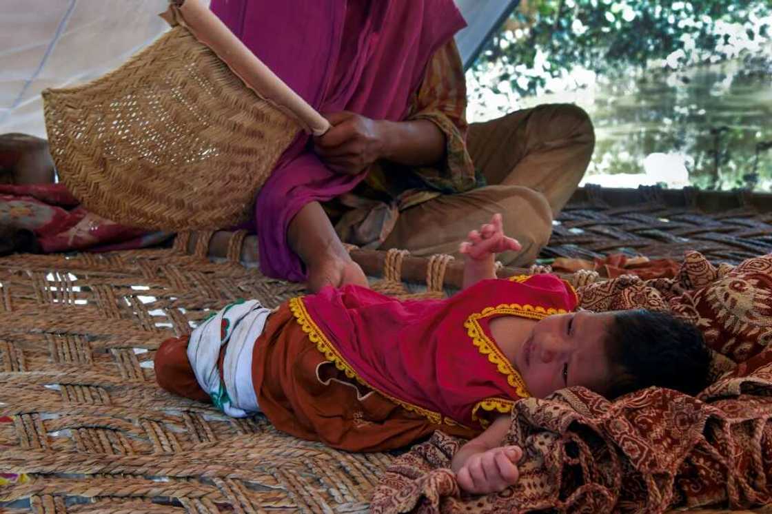 Hajira Bibi and her newborn daughter inside a tent near her flooded home in Jindi village in Khyber Pakhtunkhwa