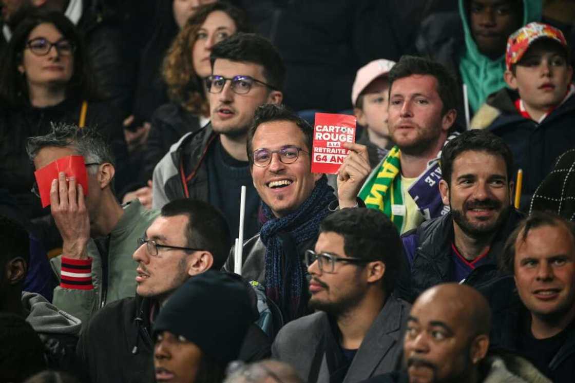 When Macron attended a football match on Saturday, some activists waved red cards at him in protest When Macron attended a football match on Saturday, some activists waved red cards at him in protest
