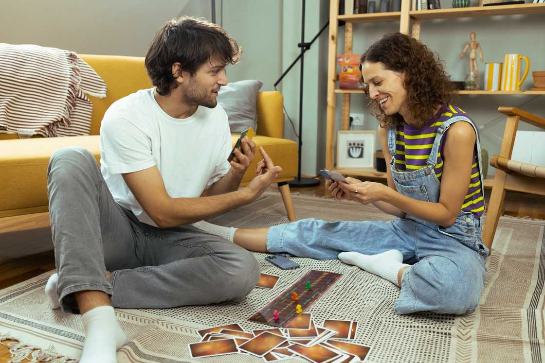 Couple playing a board game and having fun at home Couple playing a board game and having fun at home