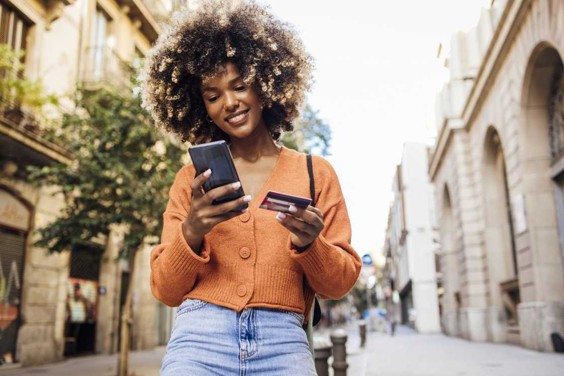 Portrait of a young woman on vacation in Barcelona shopping online on the street.