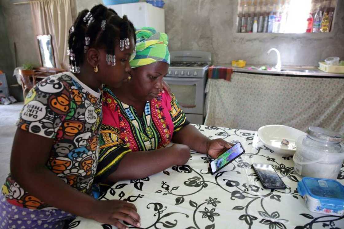 Elsy Poeketie shows her granddaughter images of her flooded holiday resort at the Moedjecreek Nieuw Lombe village in Suriname Elsy Poeketie shows her granddaughter images of her flooded holiday resort at the Moedjecreek Nieuw Lombe village in Suriname