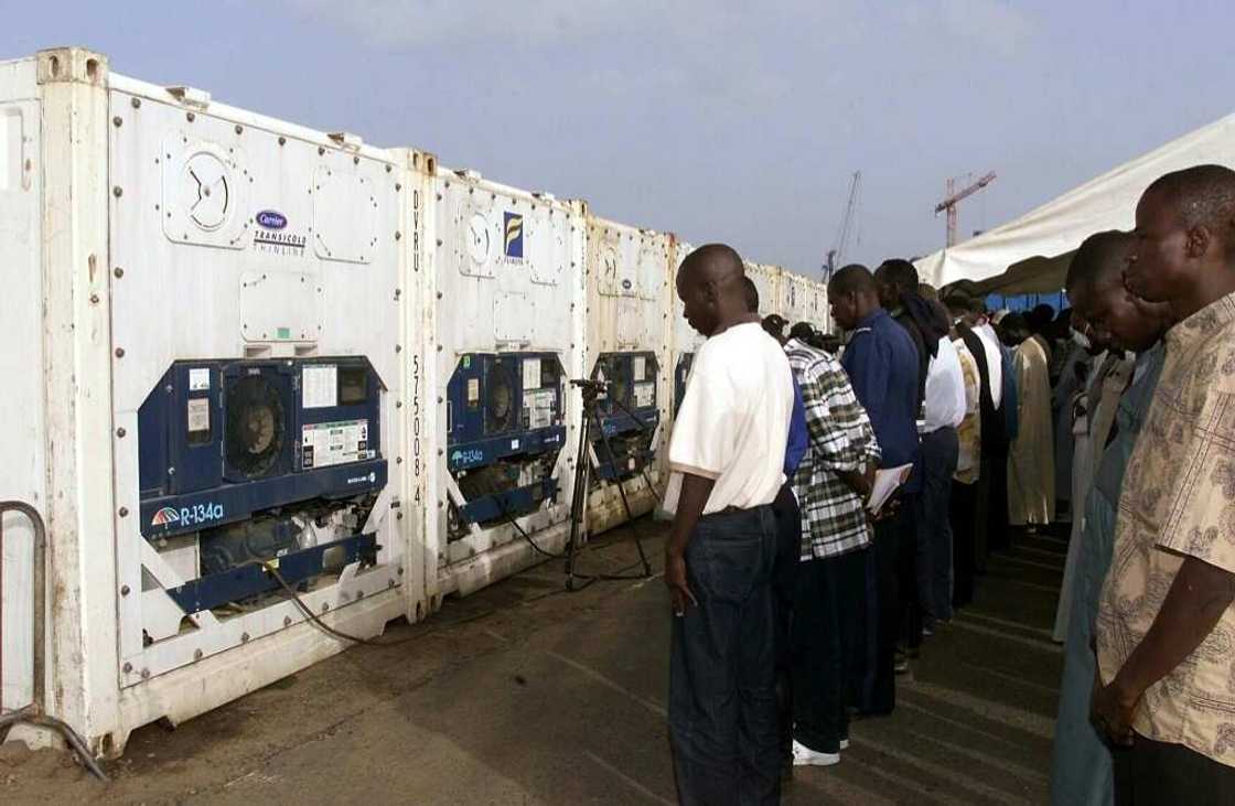Mourners gather by containers at Dakar port holding victims after the disaster Mourners gather by containers at Dakar port holding victims after the disaster