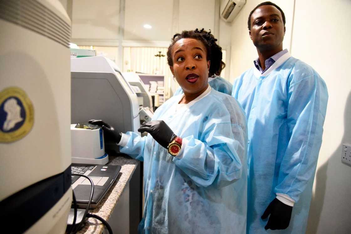 Laboratory manager, Philomena Eromon (L) and colleague molecular biologists (R) analyse COVID-19 coronavirus samples in the laboratory