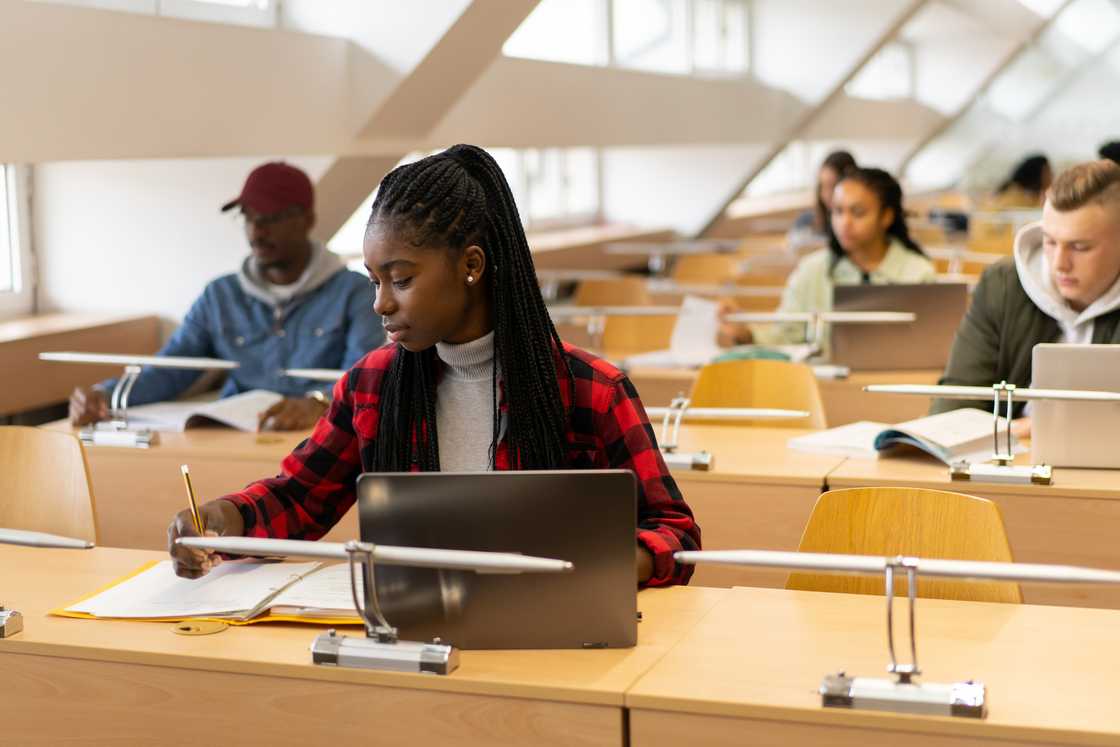 A young female student writing in the library. A young female student writing in the library.