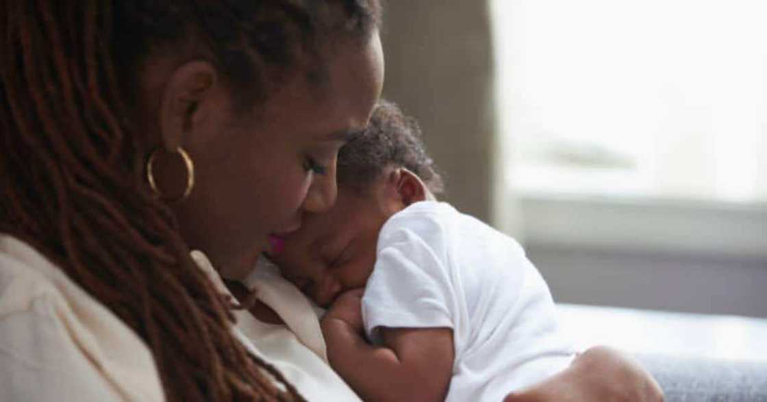 Mother cuddles her newborn chiild.